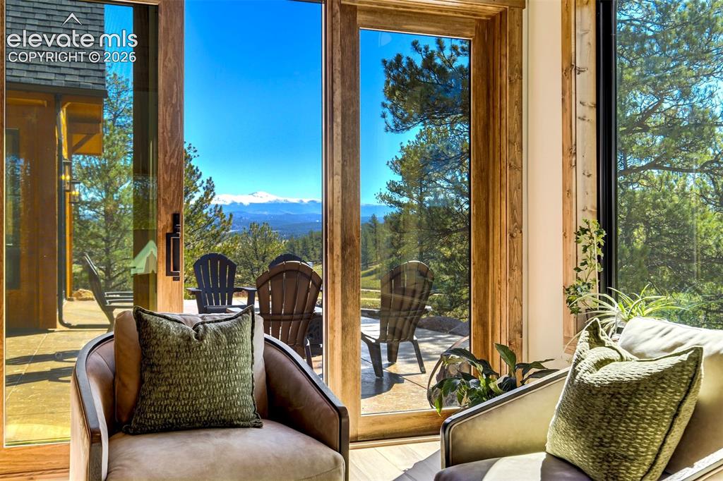 Image 13 of 50: Large glass doors, wood-frame windows, natural wood trim, patio area, and d