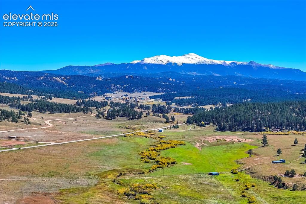 Image 36 of 50: Expansive mountain scenery featuring distant snow-capped peaks, rolling hil