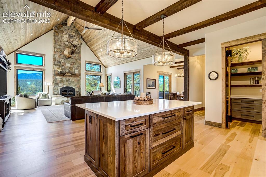 Image 8 of 50: Kitchen island with stone-finish countertop and wood-finish cabinetry, wood