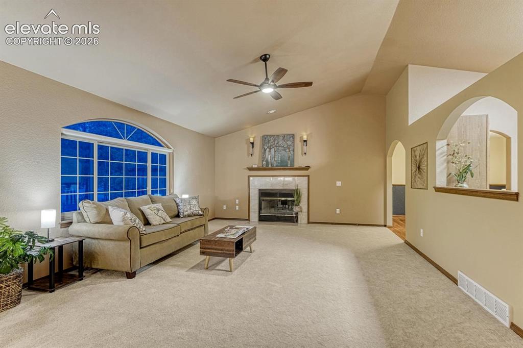Image 10 of 46: Living room with gas fireplace and ceiling fan