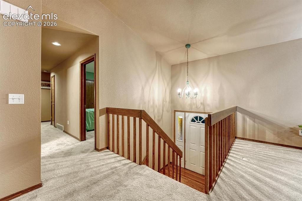 Image 14 of 46: Foyer with hardwood floor and hallway to the 3 bedrooms. New Carpet