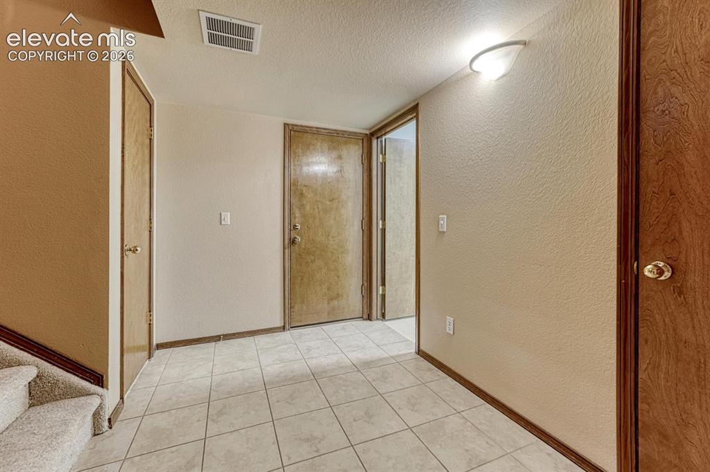 Image 34 of 46: large landing in lower level looking toward laundy and garage