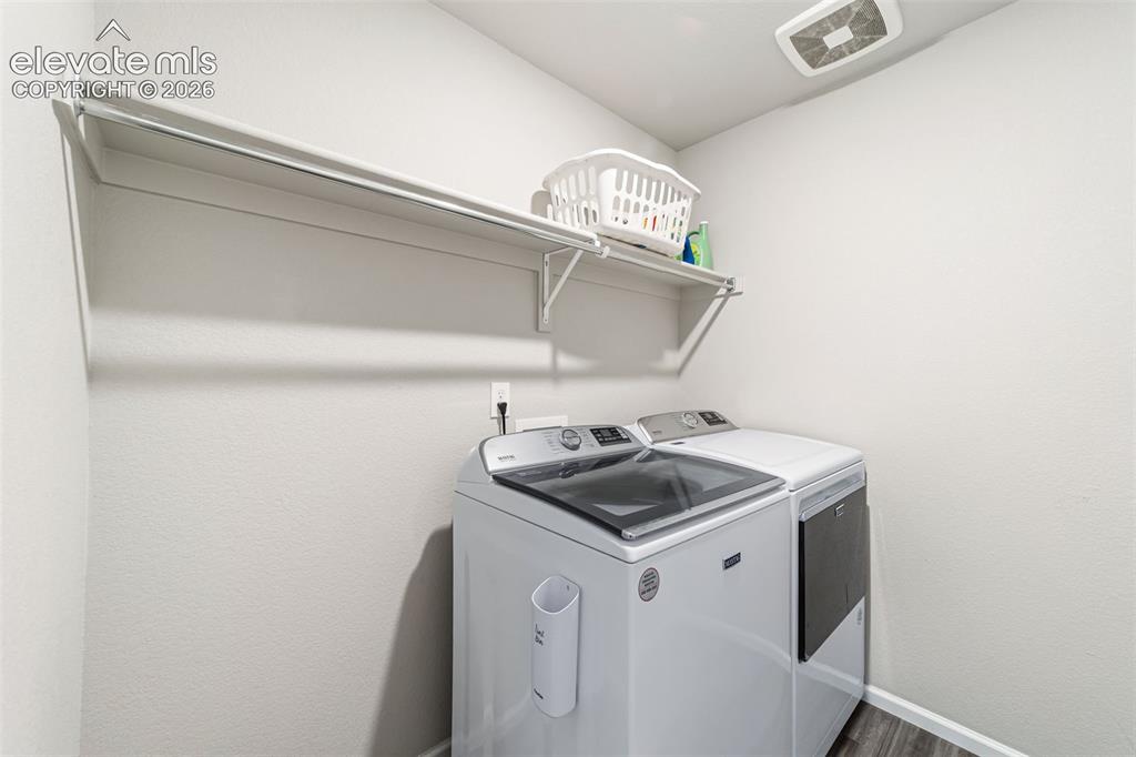 Image 15 of 21: Convenient upper-level laundry room with built-in shelving.