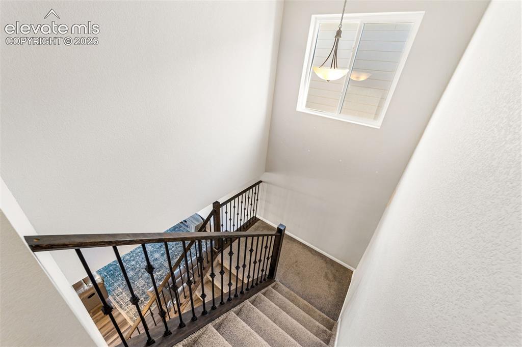 Image 16 of 21: Upper-level stairway with open railing and natural light.