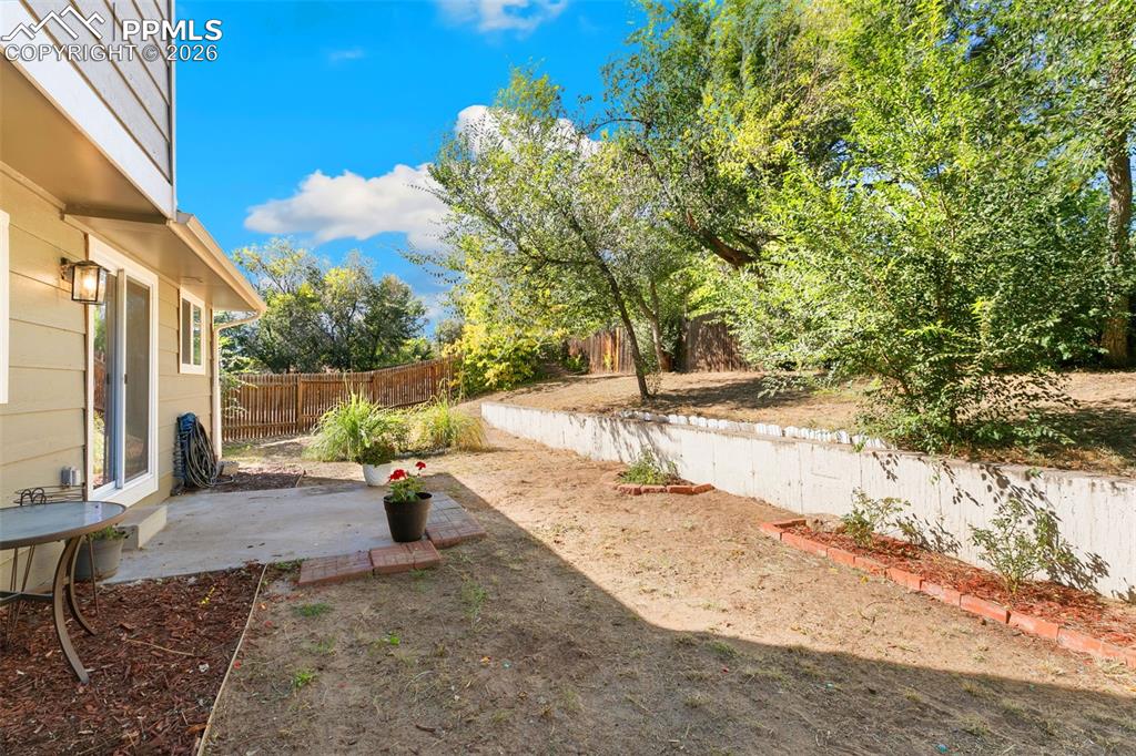 Image 13 of 28: Fenced backyard featuring a patio