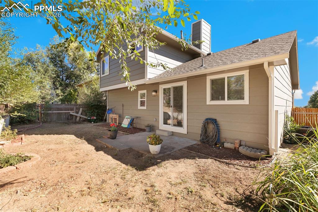 Image 5 of 28: Rear view of house with roof with shingles, a patio area, and a chimney