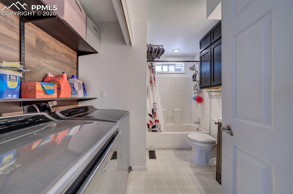 Image 19 of 46: Laundry area located in the main level bathroom.