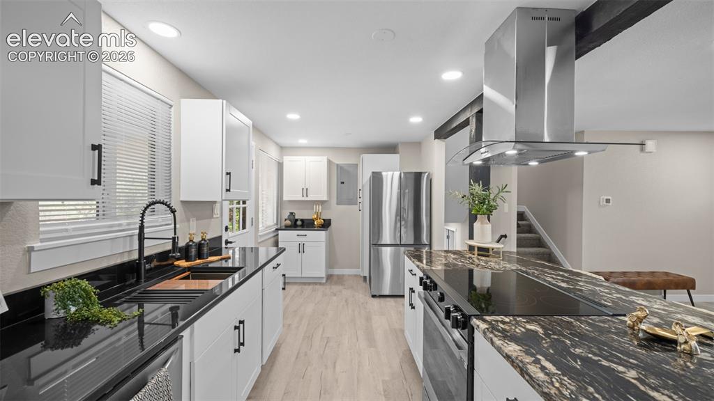 Image 10 of 45: Modern kitchen featurng island, built-in cooktop, and stainless steel range