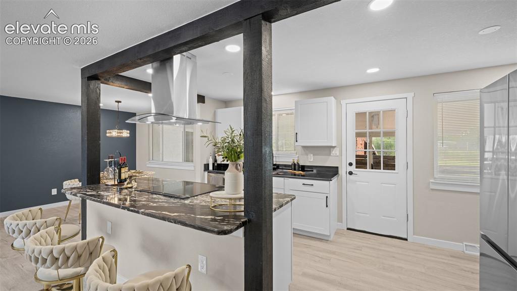 Image 13 of 45: Open-concept kitchen featuring an island with a black and brown patterned c
