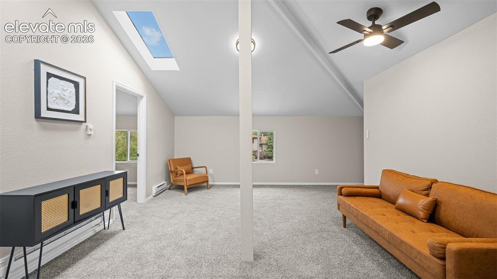 Image 32 of 45: Vaulted ceiling room featuring a skylight, light grey carpeting, recessed l