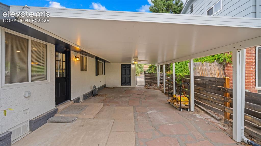 Image 33 of 45: Covered patio with flagstone and concrete flooring