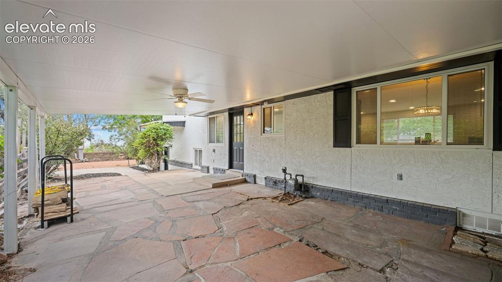 Image 34 of 45: Covered patio featuring flagstone flooring, a ceiling fan, and a stucco ext