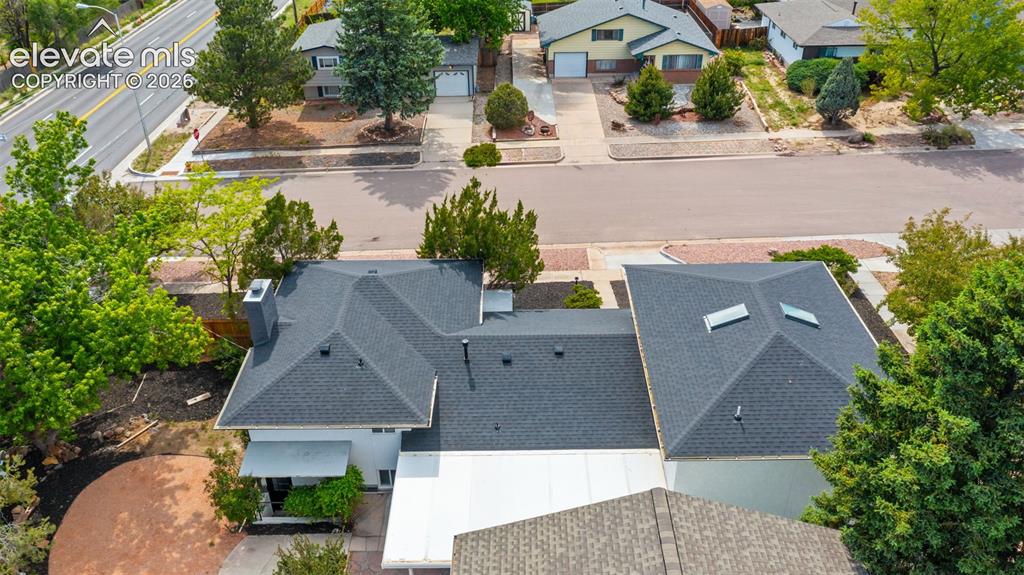 Image 40 of 45: Modern roofing system with skylights, multiple gables, and a prominent chim