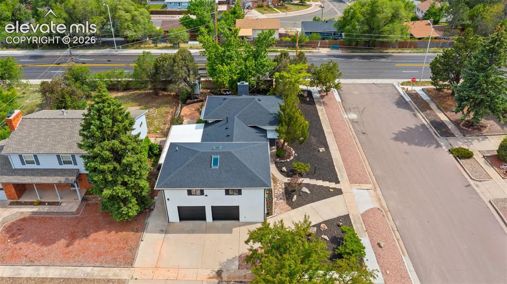 Image 41 of 45: White two-story residence featuring a two-car garage with black doors, a da