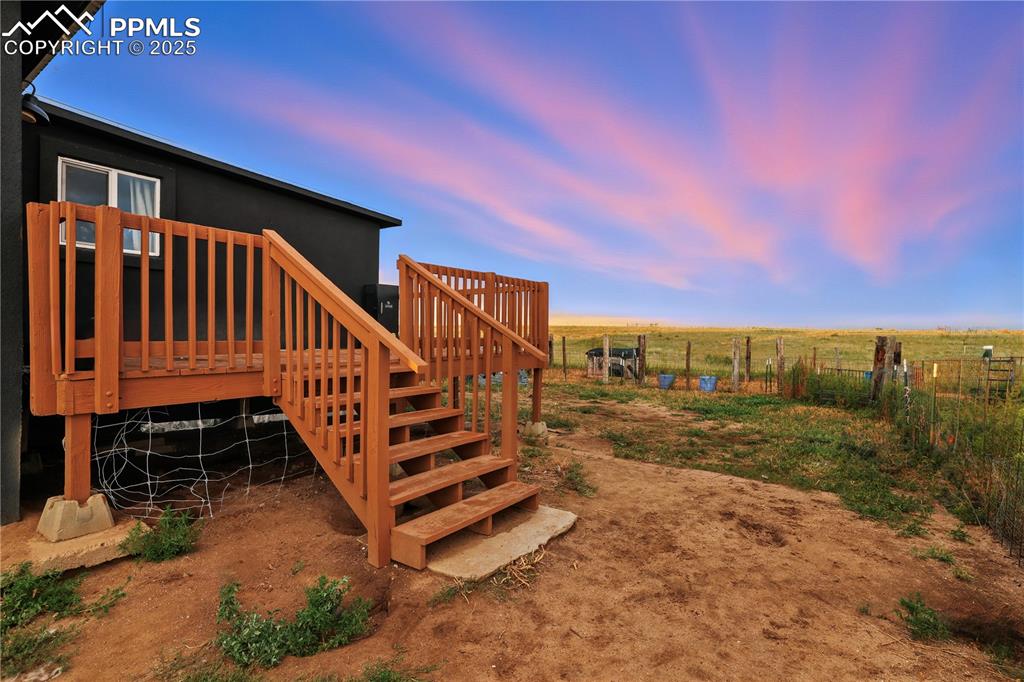 Image 12 of 50: Step down into the fully fenced back yard