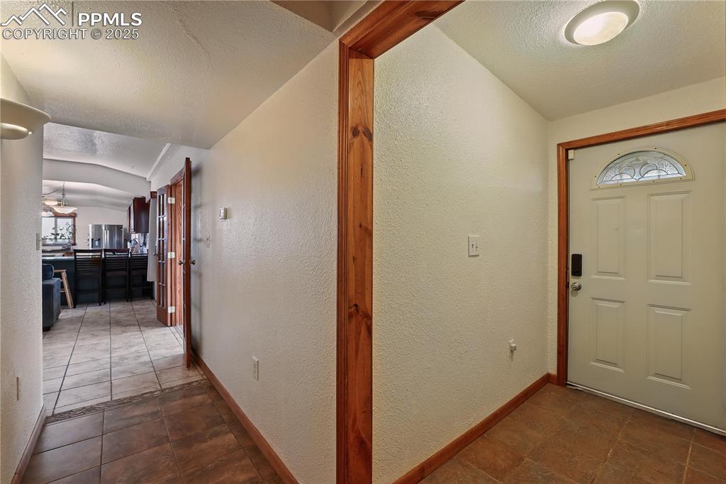 Image 22 of 50: Entry to the home features tile flooring with custom accents