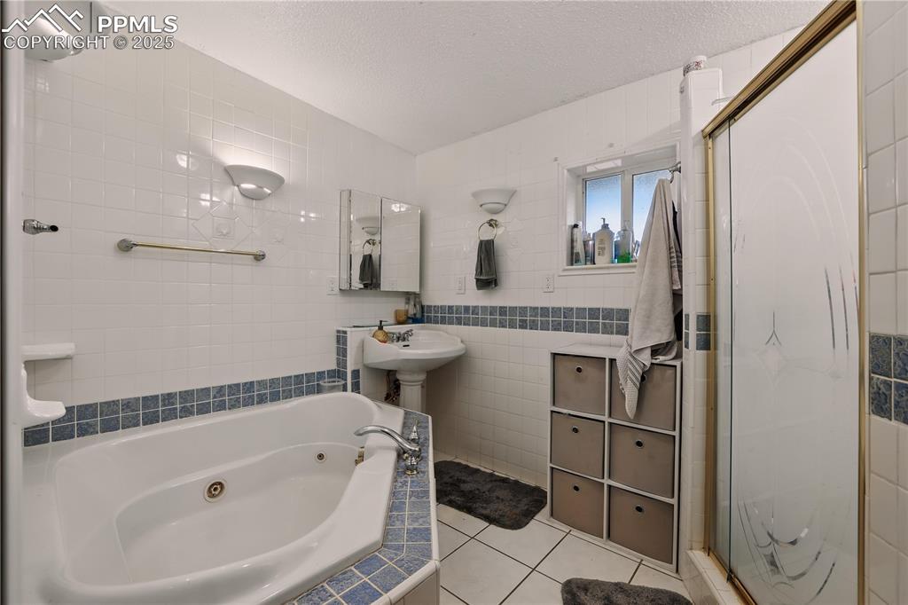 Image 26 of 50: Spa-like primary bathroom with a jetted tub and separate shower