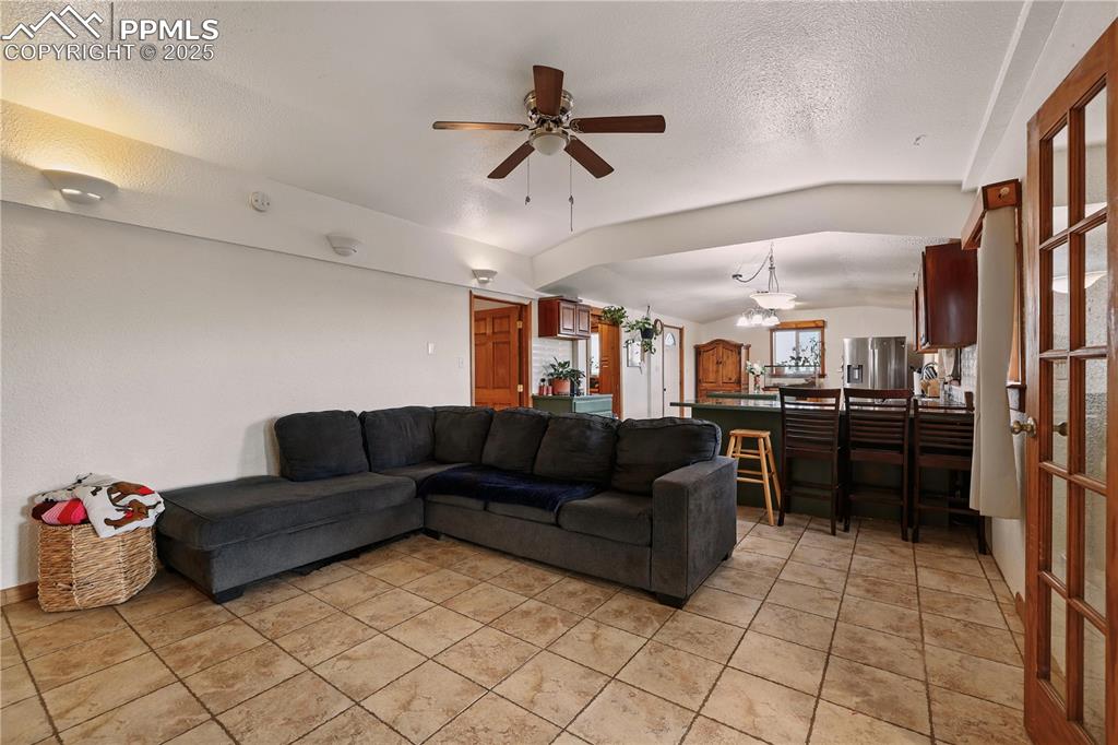 Image 5 of 50: Living room opens to the kitchen with a beautiful lofted ceiling.