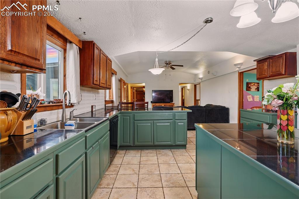 Image 8 of 50: Kitchen features stunning black counters and freshly painted hunter green c