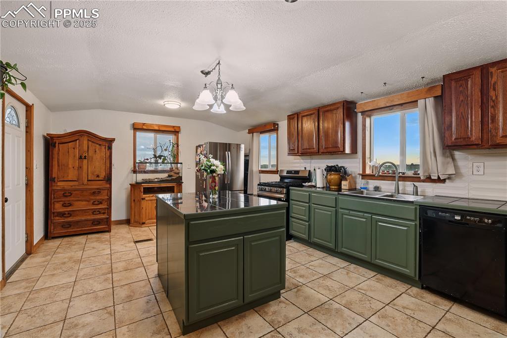 Image 9 of 50: Kitchen features stainless appliances including a gas range and custom tile
