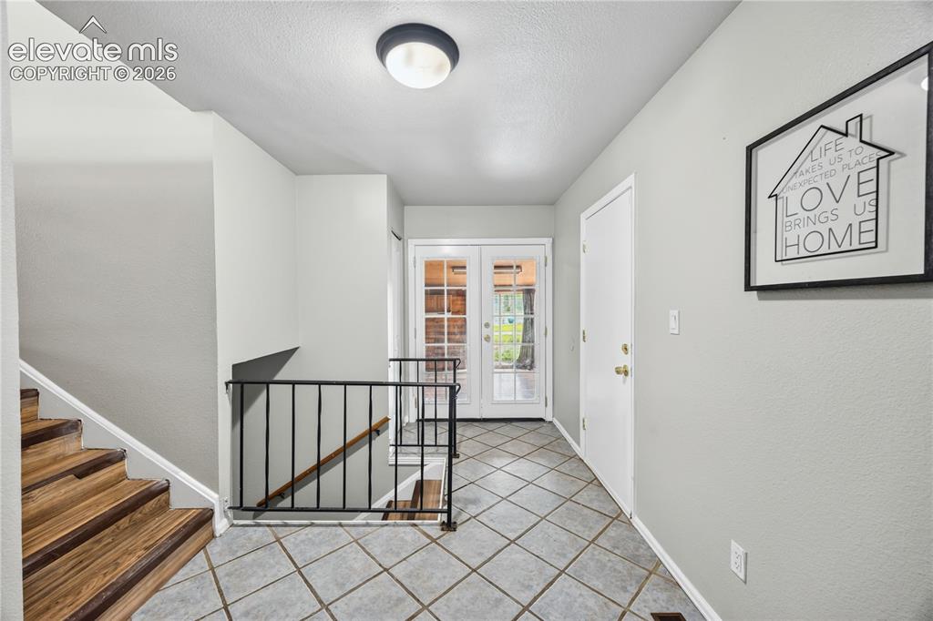 Image 5 of 34: Front Tiled Entry with stairs to the upper and lower levels.