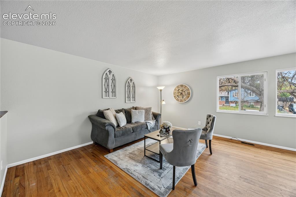 Image 7 of 34: Main Level Vaulted Recreation Room with wood paneled walls, wood laminate a