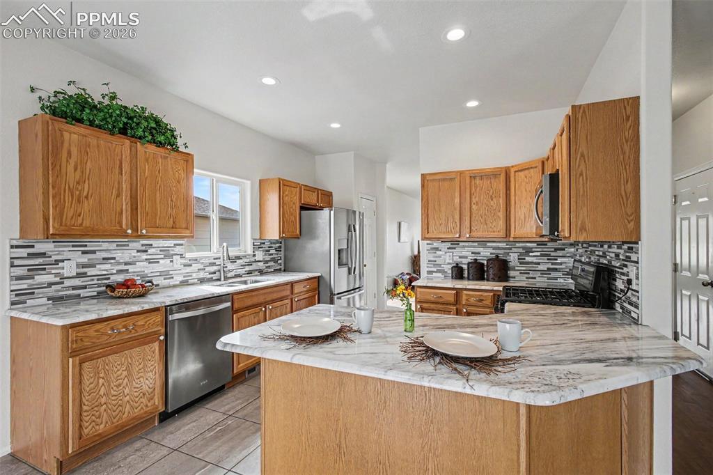Image 11 of 40: The chef-inspired kitchen boasts updated stone countertops, stainless steel