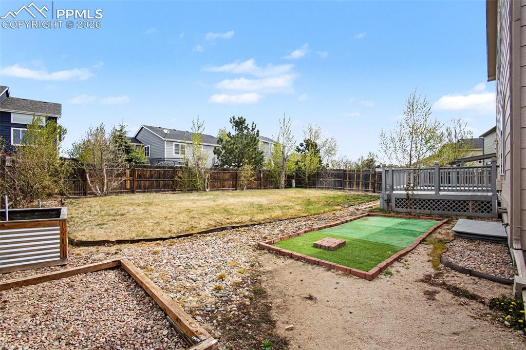 Image 29 of 40: Private, landscaped back yard with raised planter