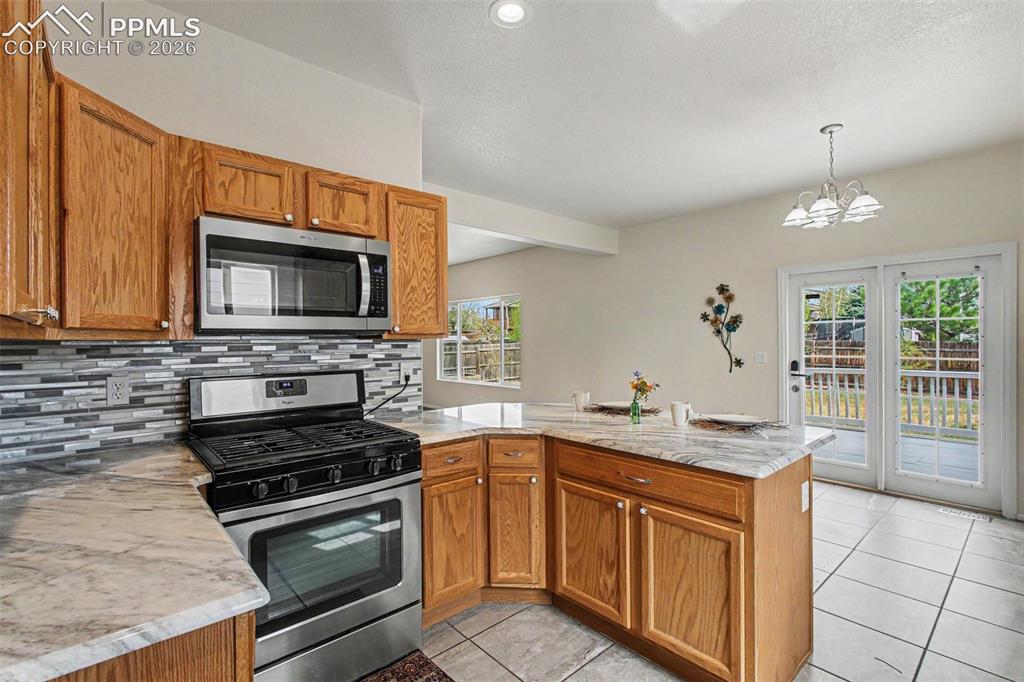 Image 8 of 40: Beautiful tile backsplash and stainless steel appliances
