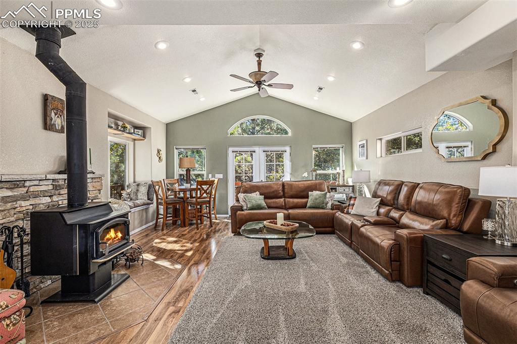 Image 11 of 47: Dining area with a textured wall, wood finished floors, and vaulted ceiling
