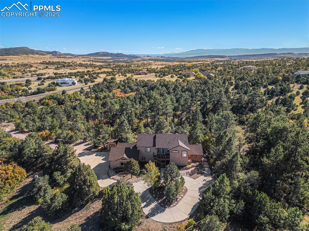 Image 2 of 47: Kitchen with white cabinetry, hanging light fixtures, dark tile patterned f