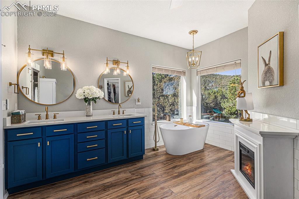 Image 22 of 47: Ensuite bathroom with double vanity, dark wood finished floors, a shower st