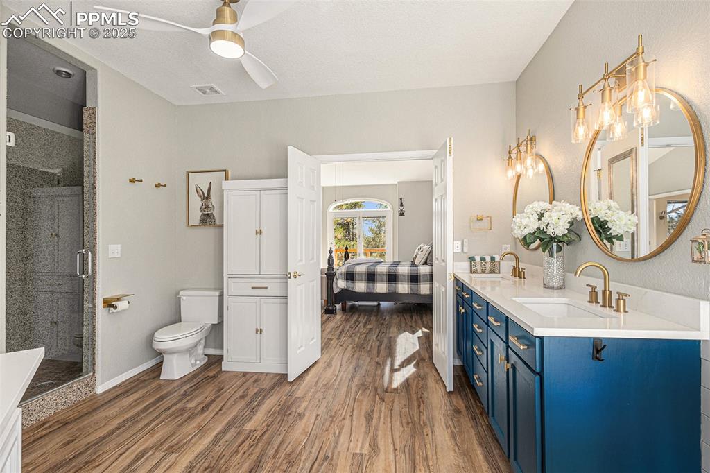 Image 23 of 47: Full bathroom with a walk in closet, wood finished floors, a shower stall, 