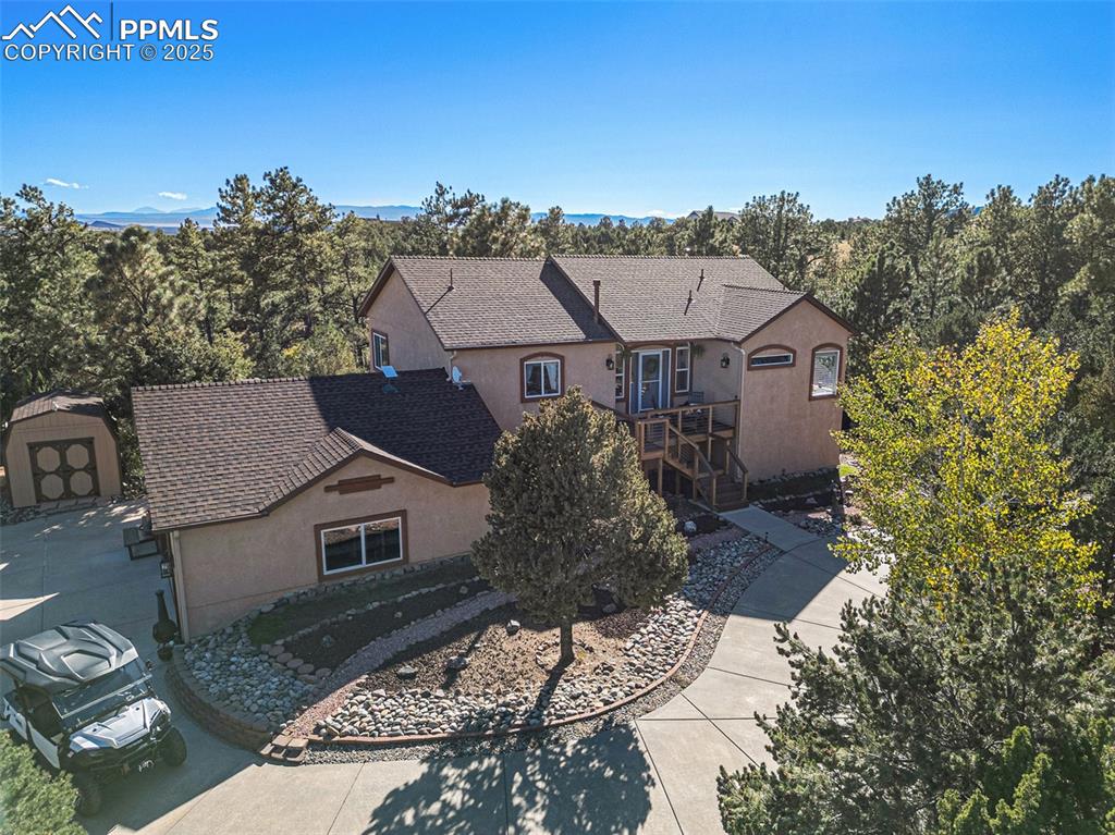 Image 40 of 47: View of front of house featuring a wooden deck, stucco siding, a shingled r