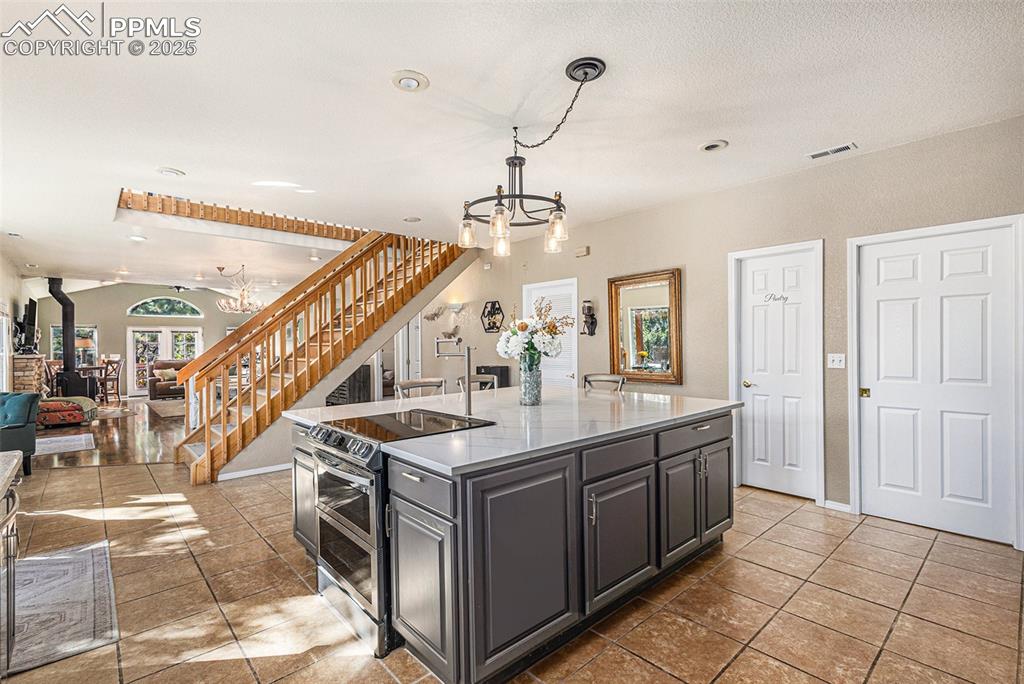 Image 5 of 47: Kitchen with white cabinets, decorative light fixtures, stainless steel app