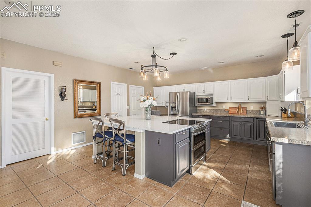 Image 6 of 47: Living room with a wood stove, high vaulted ceiling, wood finished floors, 