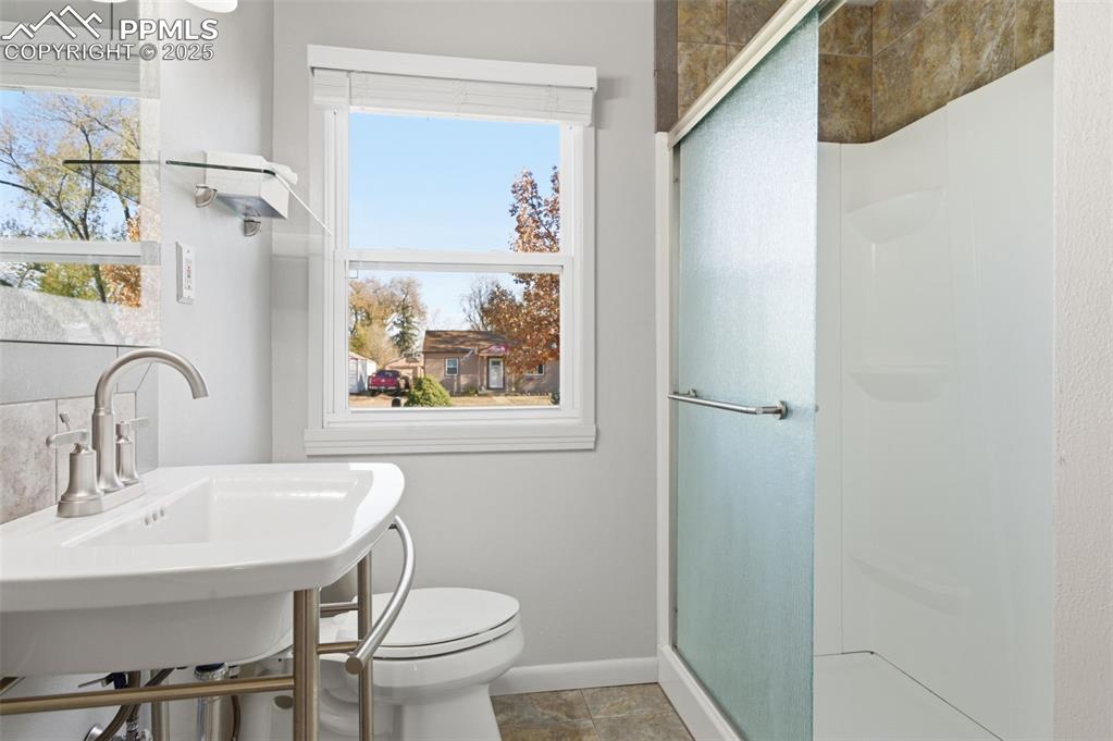 Image 30 of 50: Full bath featuring a stall shower and toilet