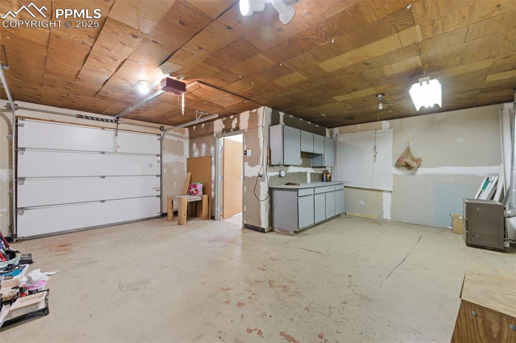 Image 38 of 50: Garage featuring wood ceiling and a garage door opener