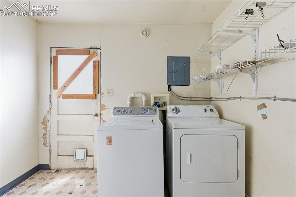 Image 39 of 50: Laundry area featuring electric panel and washing machine and dryer