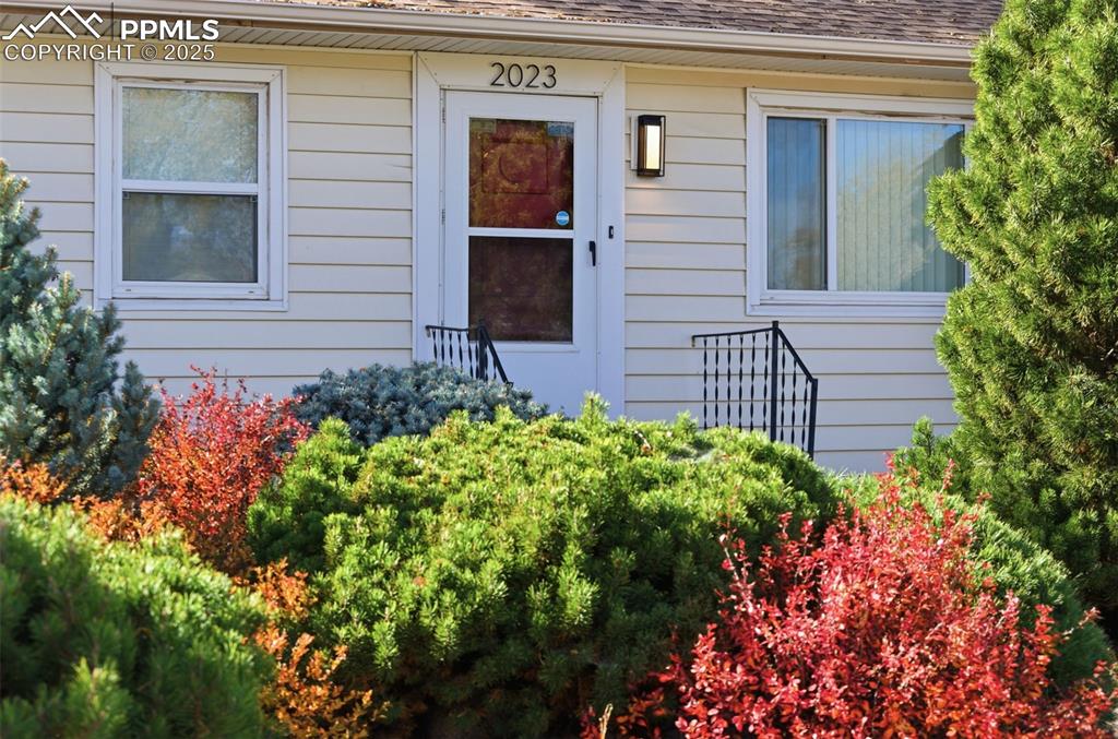 Image 9 of 50: Property entrance with a shingled roof