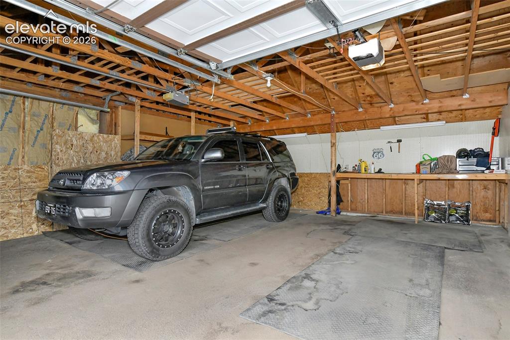 Image 22 of 22: Garage interior and storage/workbench