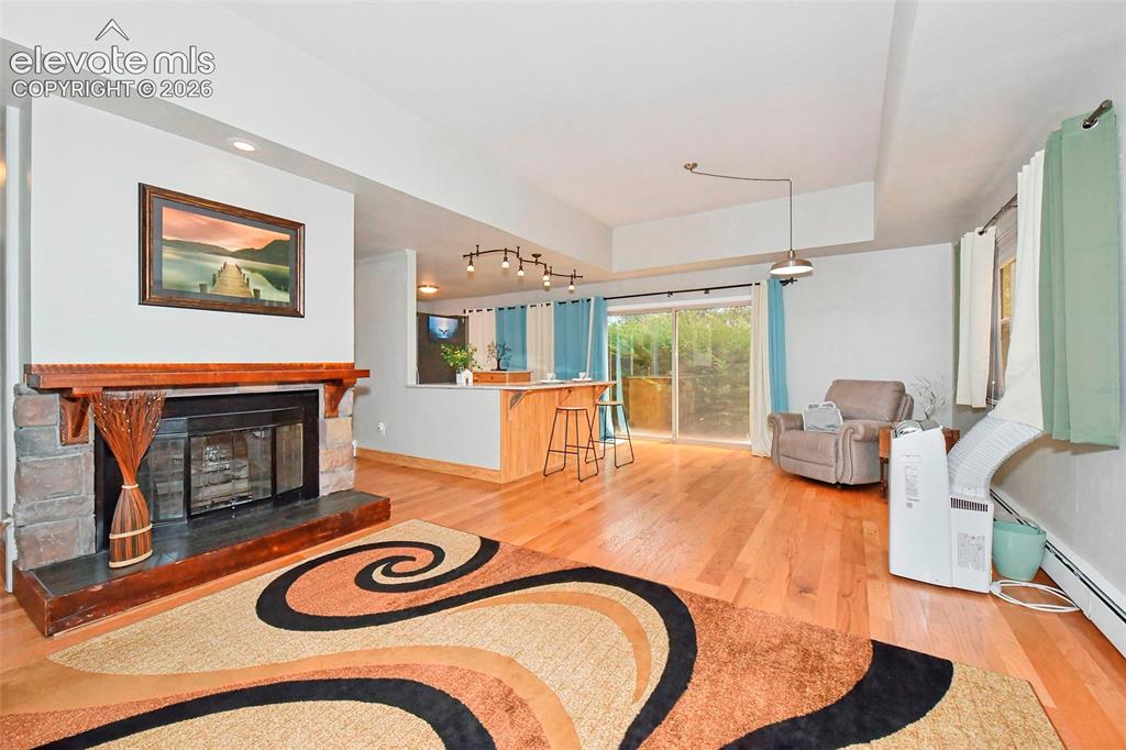 Image 4 of 22: fireplace, hardwood floors and patio access