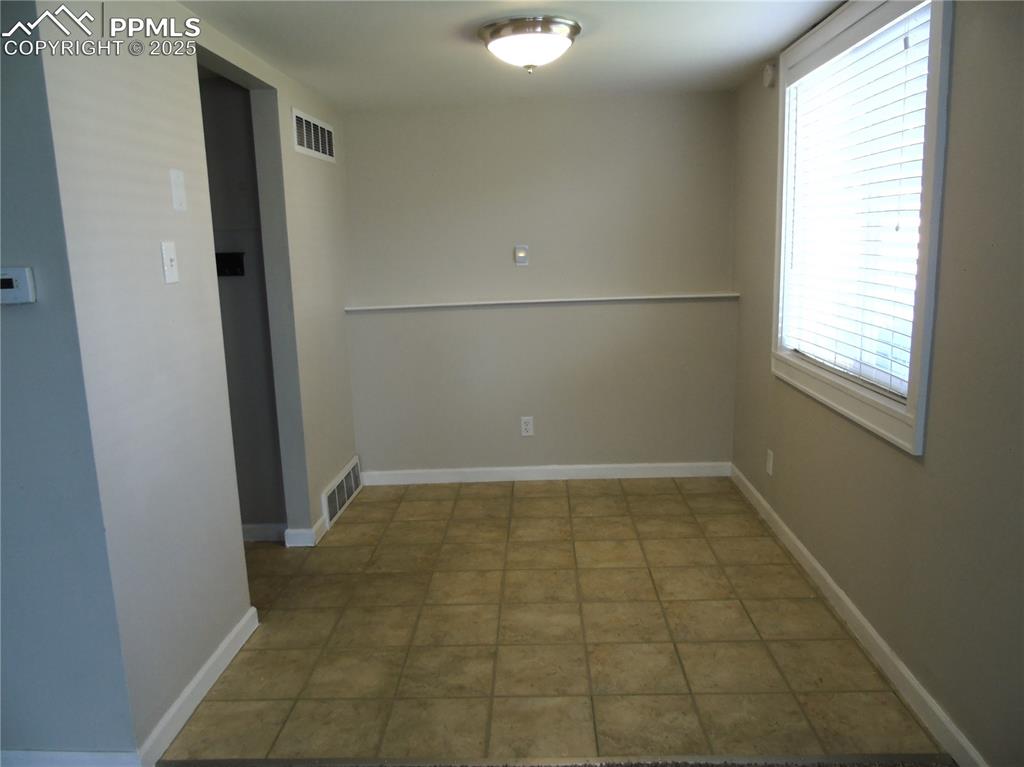 Image 11 of 29: Unfurnished room featuring baseboards and light tile patterned flooring