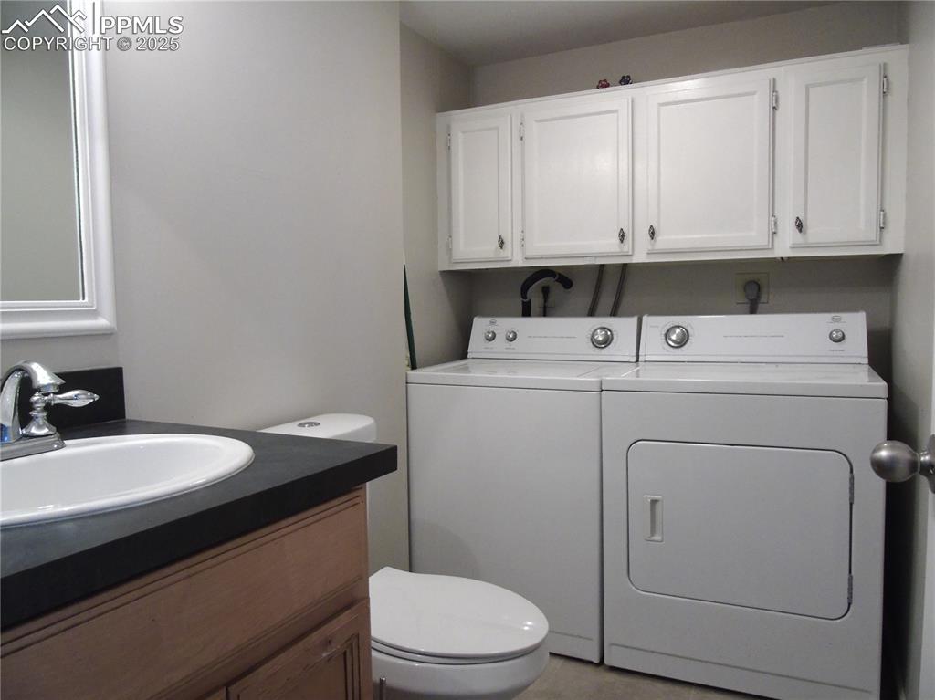 Image 13 of 29: Bathroom featuring vanity, separate washer and dryer, and light tile patter