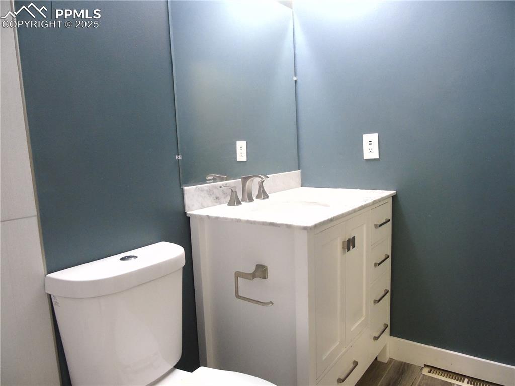 Image 19 of 29: Half bath featuring vanity and wood finished floors