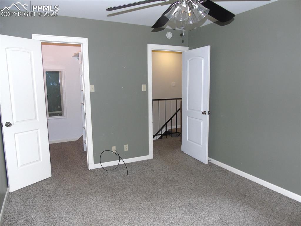 Image 21 of 29: Unfurnished bedroom with carpet floors and a ceiling fan
