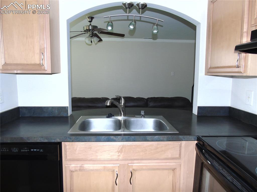 Image 7 of 29: Kitchen featuring dark countertops, black appliances, light brown cabinets,