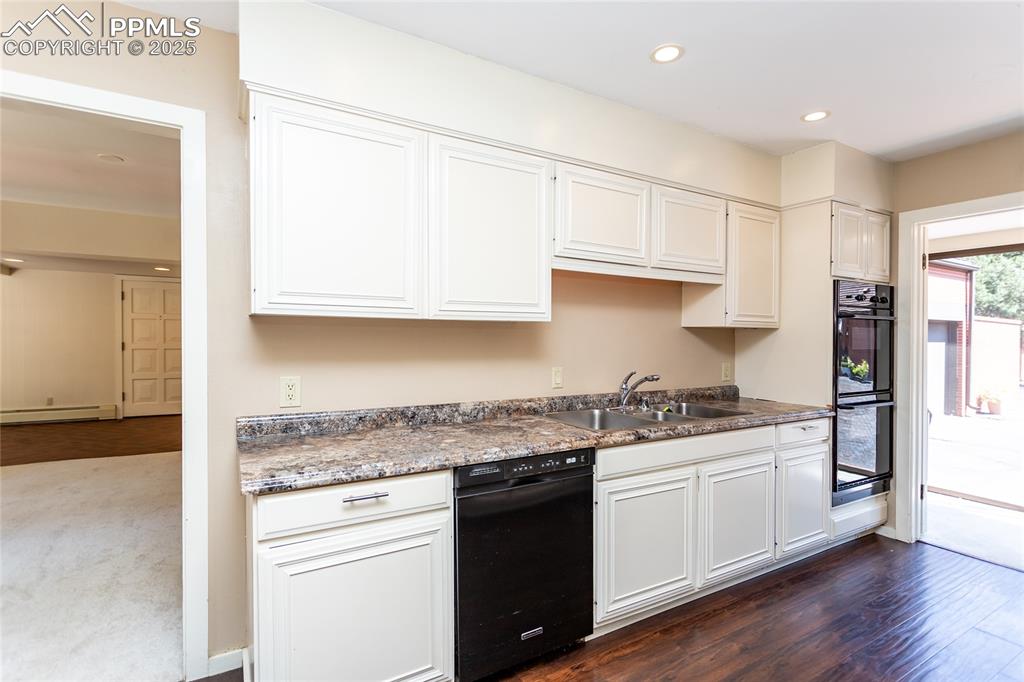Image 11 of 35: Kitchen with recessed lighting, dark wood-type flooring, white cabinets, da