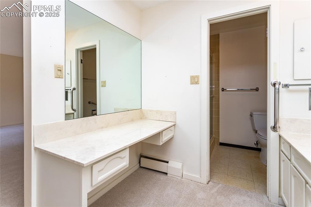 Image 17 of 35: Bathroom featuring vanity, a baseboard heating unit, a shower with shower d