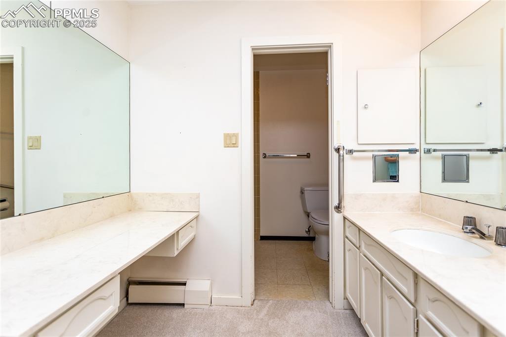 Image 18 of 35: Bathroom with vanity, a baseboard radiator, and light tile patterned floors